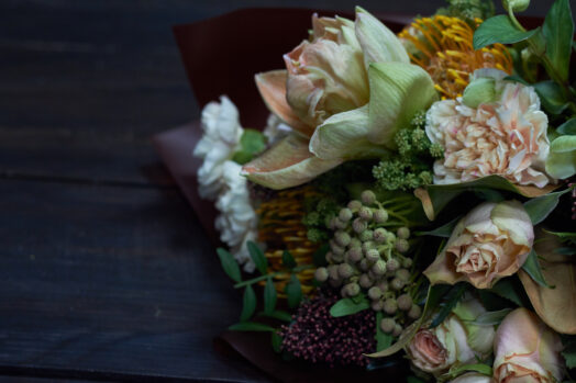 En närbild av en blomsterbukett med olika blommor och grönt.